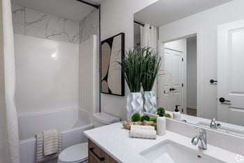 A white bathroom with a white toilet and a white sink.